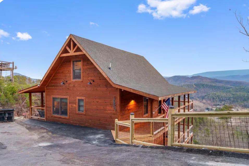 Front of the cabin with timber siding, a covered porch, and Smoky Mountain views