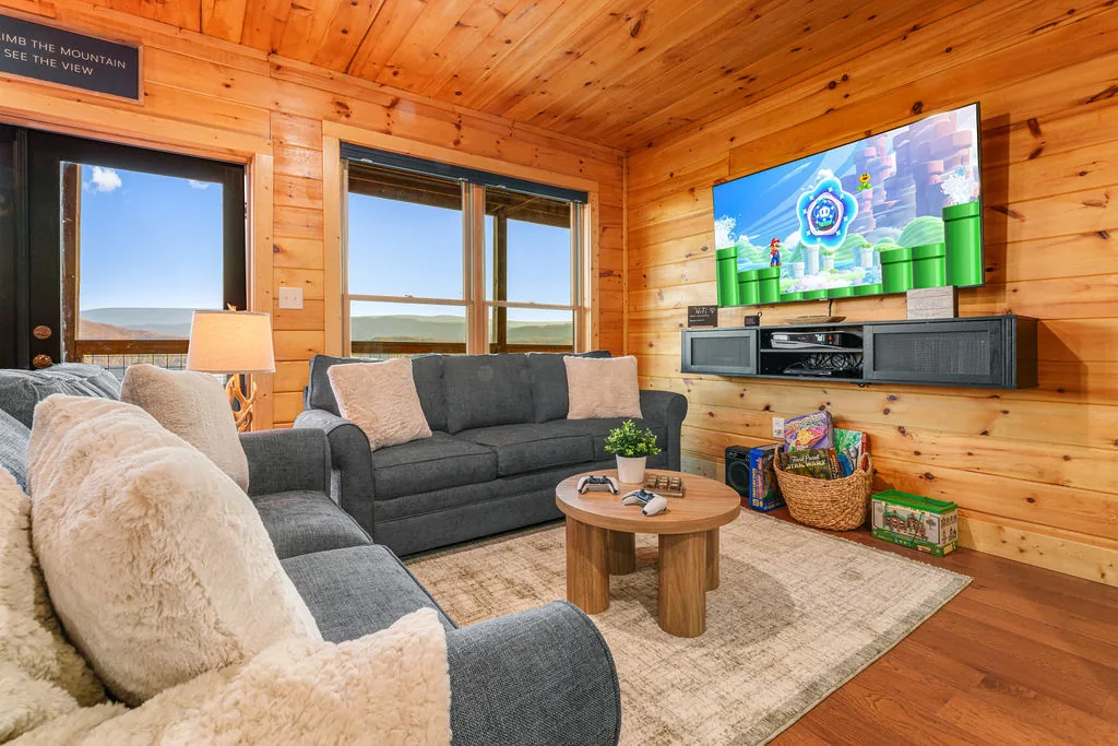 Lower-level den with a smart TV, sofa, and armchairs