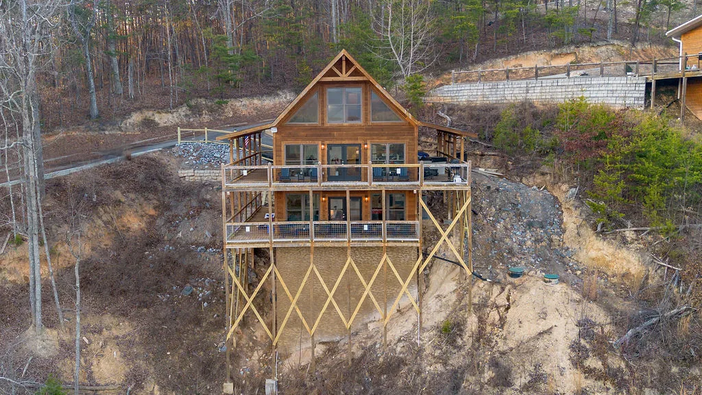 Aerial view of the cabin perched on its ridge above the treeline