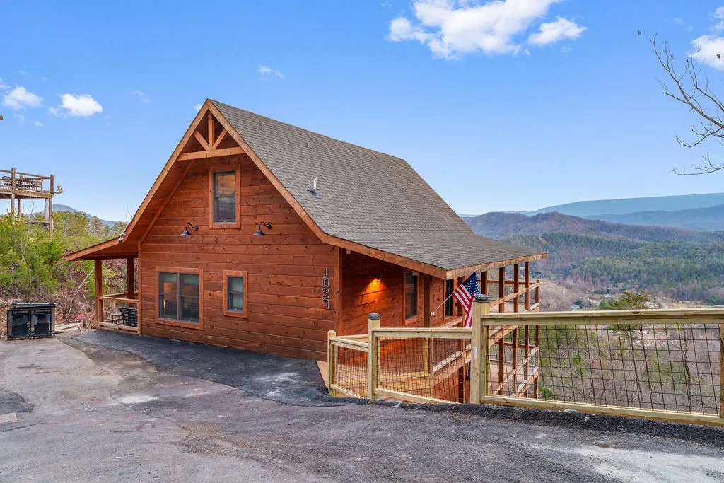 Front exterior of Rylan's Mountain Retreat, a two-story timber cabin on a wooded ridge