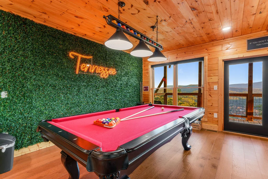 Game room lounge with sectional seating, a coffee table, and windows facing the mountains