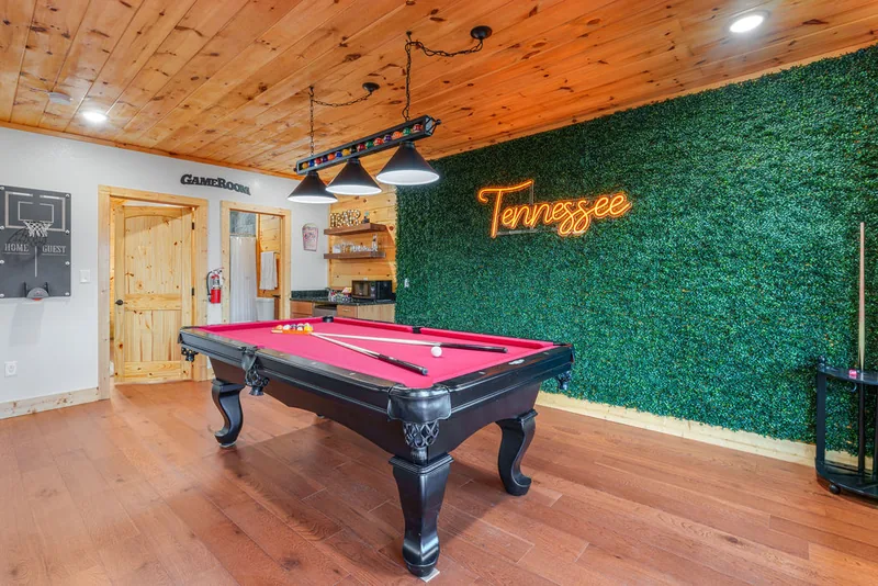 The game room at Rylan's Mountain Retreat with a full-size pool table and neon Tennessee sign