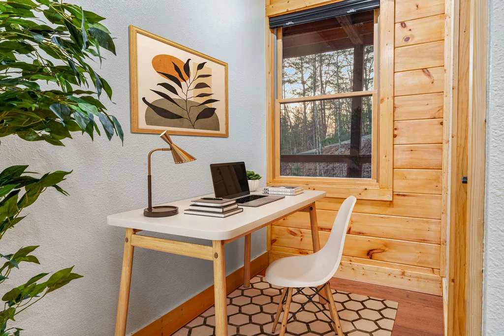 Small desk and chair set up as a workspace beside a bedroom window
