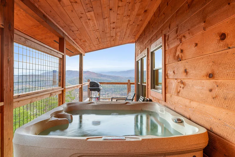 Private hot tub on the covered deck with the Smoky Mountain ridgeline behind it