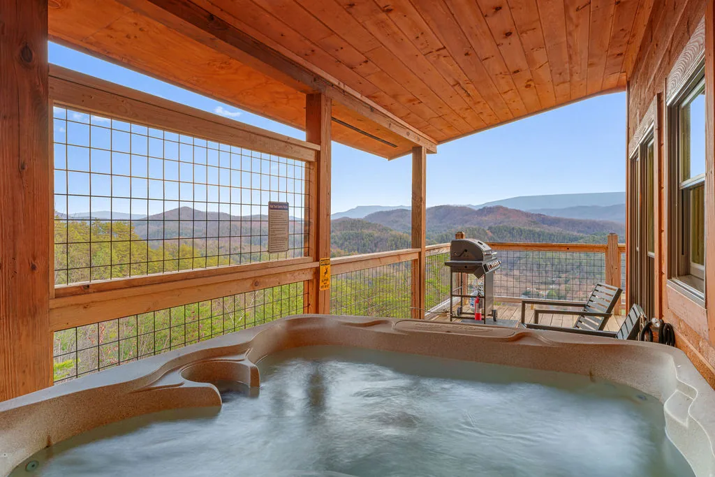 Hot tub on the deck looking out across layered blue mountain ridges