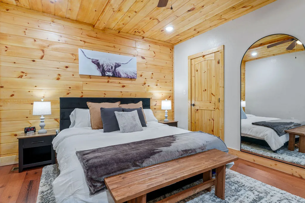 Second king bedroom with nightstands, lamps, and framed mountain artwork