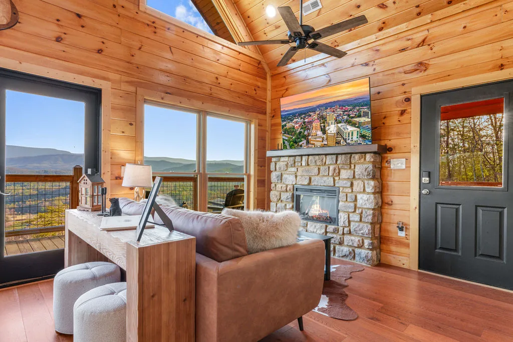Open living area with vaulted pine ceiling and an antler chandelier above the seating