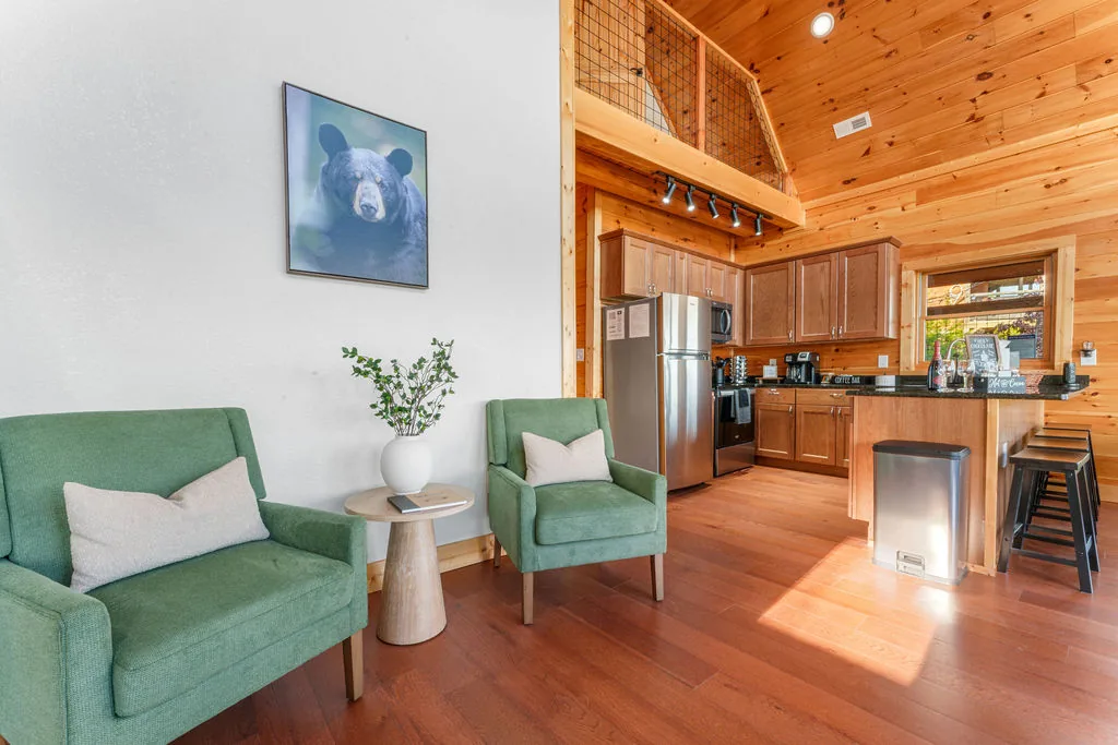 Upstairs loft sitting area with two green armchairs beside a side table