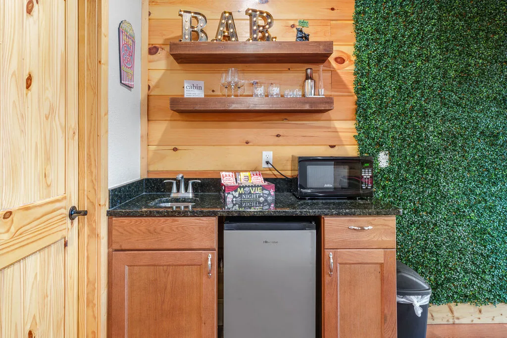 Wet bar with a granite counter, mini fridge, and open shelving